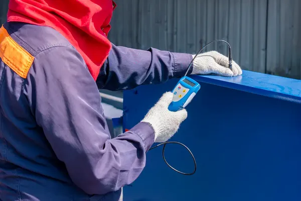 Professional powder coating technician applying polyurethane coating to steel